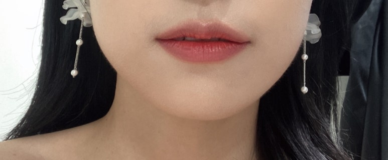 핑크 코랄 립과 깨끗한 피부가 보이는 입매 근접샷이에요.