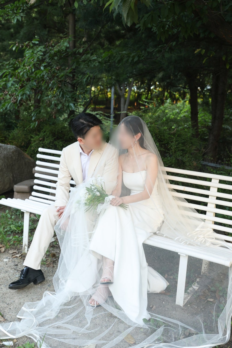 흰 벤치에서 베일을 쓰고 기대앉은 컷
