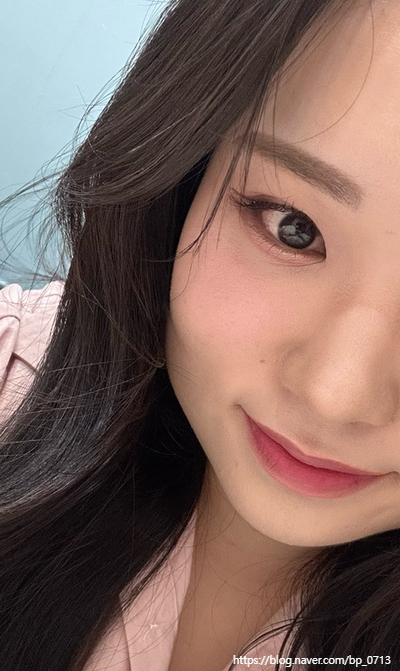 핑크 블러셔와 립, 붙인 속눈썹이 함께 보이는 얼굴 근접샷이에요.