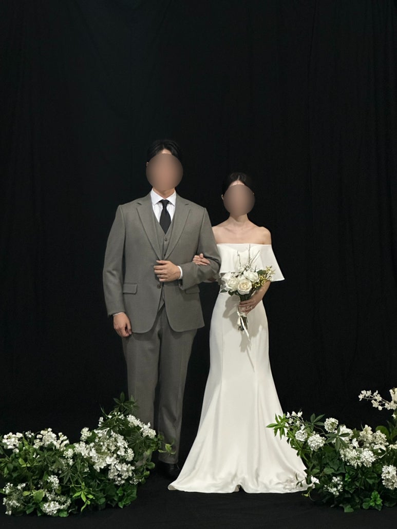 검정 배경과 초록 화단 앞 커플 전신
