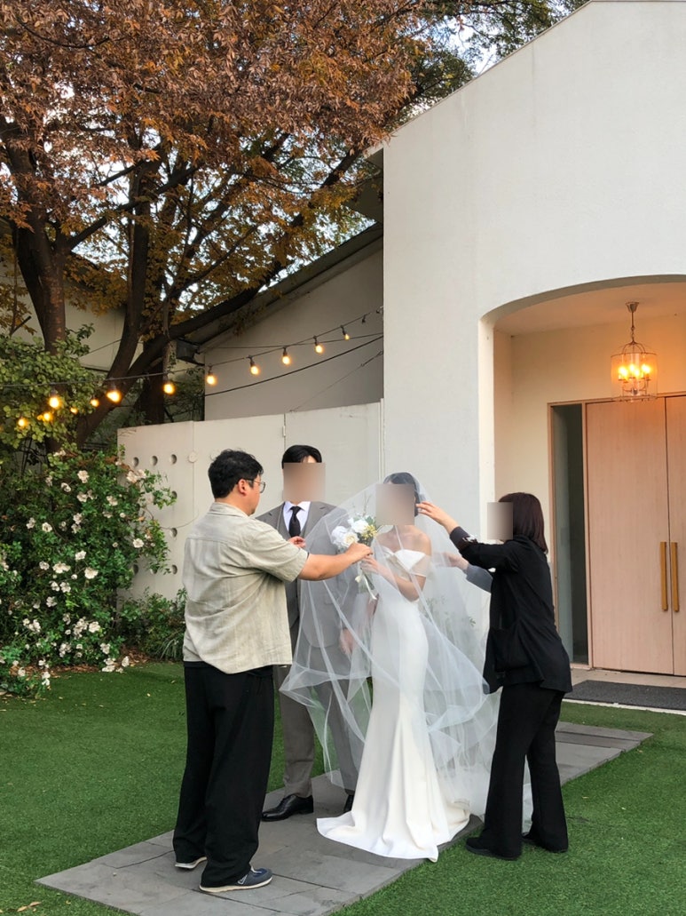 잔디 마당, 나무 양문과 샹들리에 앞에서 준비 중인 신부