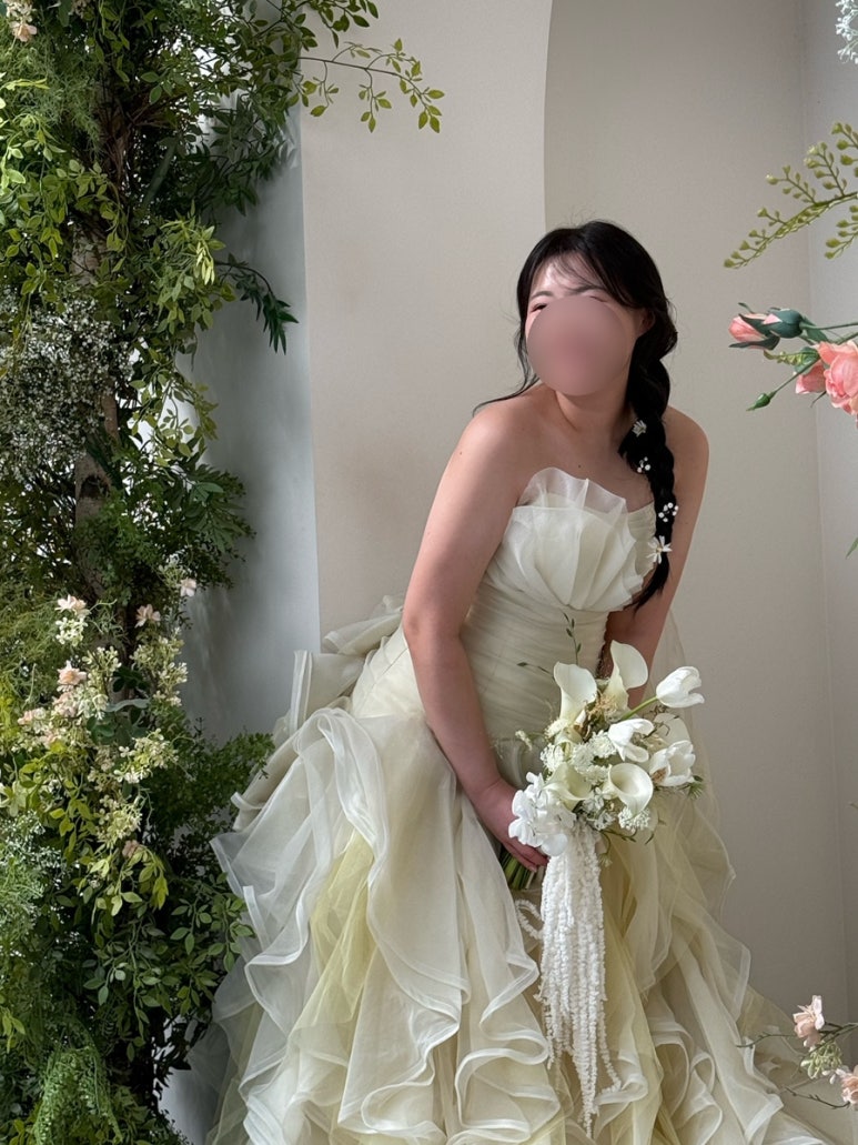 노랑 유색 드레스에 마가렛 생화를 꽂은 땋은 머리