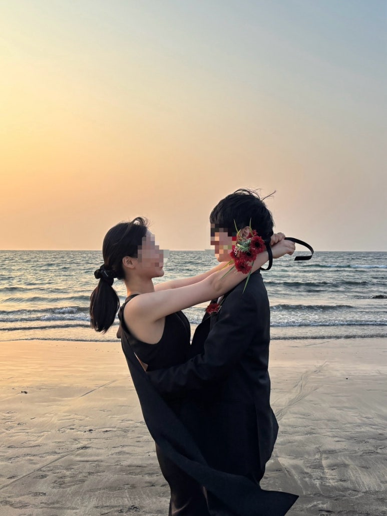 해 질 녘 제주 바닷가에서 올블랙 커플이 서로 끌어안는 컷이라 블랙 웨딩룩 참고용으로 좋아요.