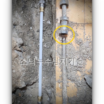 바닥을 길게 굴착한 홈에 기존 강관을 잘라내고 새 배관을 연결해 둔 수리 구간