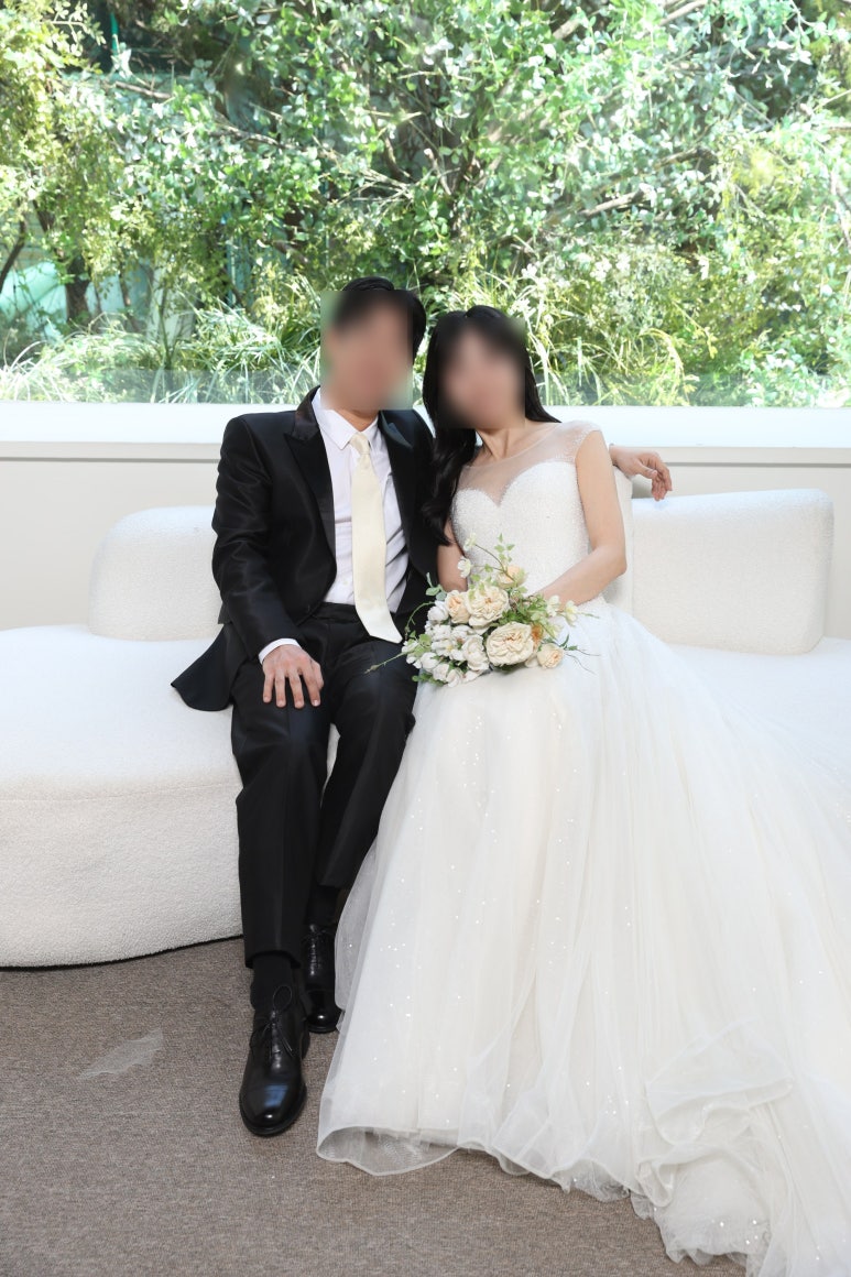 통창 창턱에 기대 앉은 커플, 옆에 흰 소파