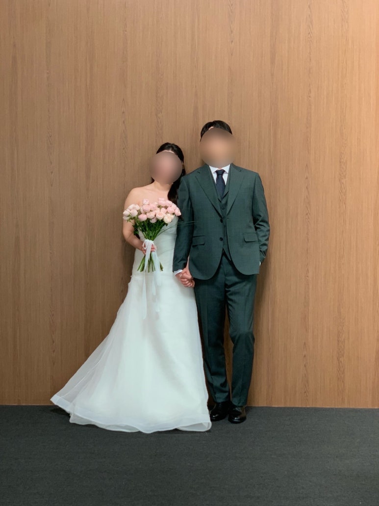 나무 벽 앞에 나란히 선 커플 전신
