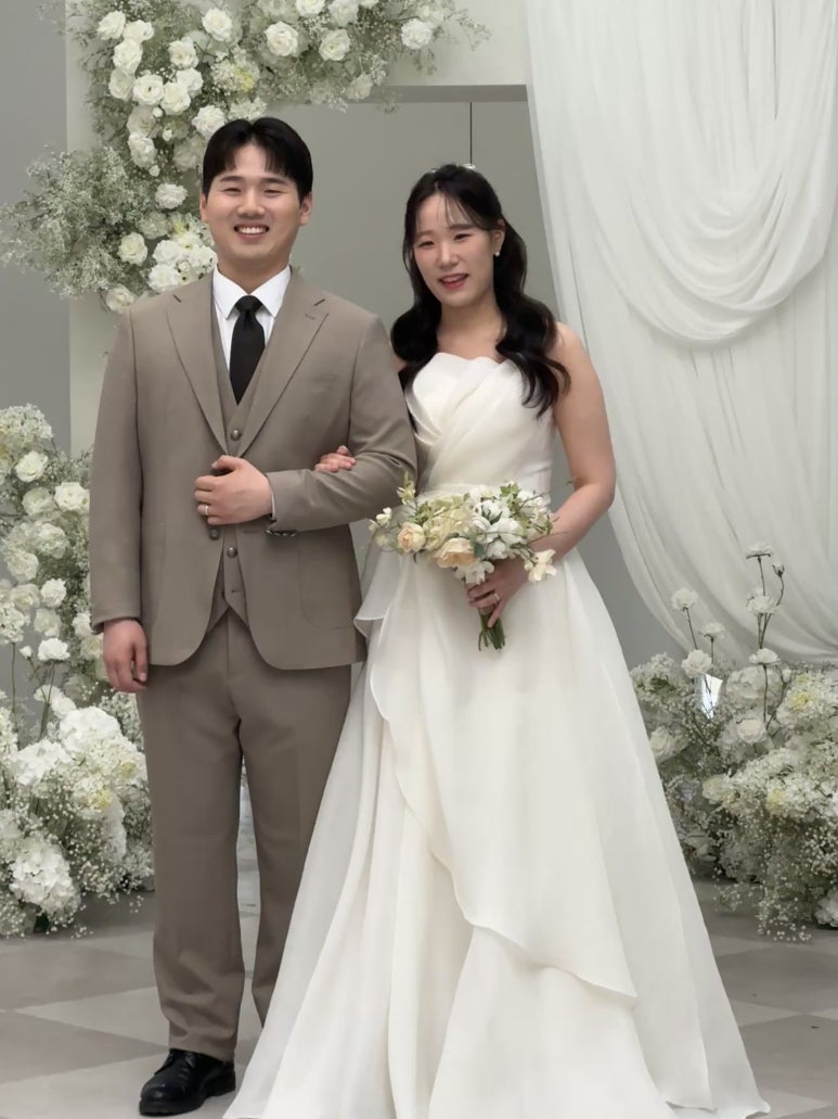 흰 꽃 아치 앞 커플 반신