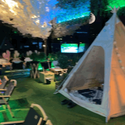 Interior of T.AGE Indoor Camping with tents and lighting