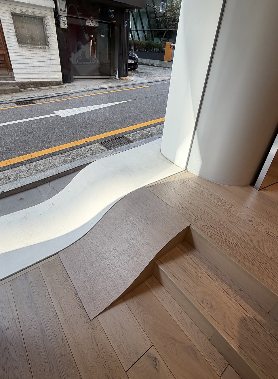 곡선은 창가 단차까지 이어지고, 거리의 빛을 실내 깊숙이 끌어들인다.