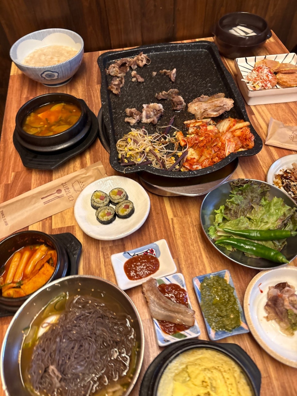 매콤한 떡볶이와 부드러운 계란찜 등 W냉삼에서 기본으로 제공되는 다채로운 반찬들
