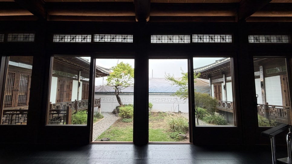 짙은 실내와 밝은 중정 사이. 블루재에서 오래된 시간은 배경이 아니라 오늘의 빛을 받아들이는 틀이 된다.
