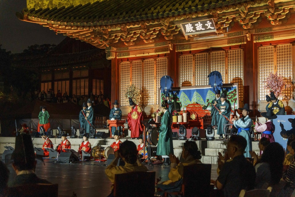 밤의 창경궁 문정전 앞마당에서 궁중 복식을 입은 출연자들이 공연하는 장면