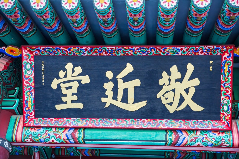 A close view of the Chinese-character signboard reading Gyeongeundang, hung under the eaves.