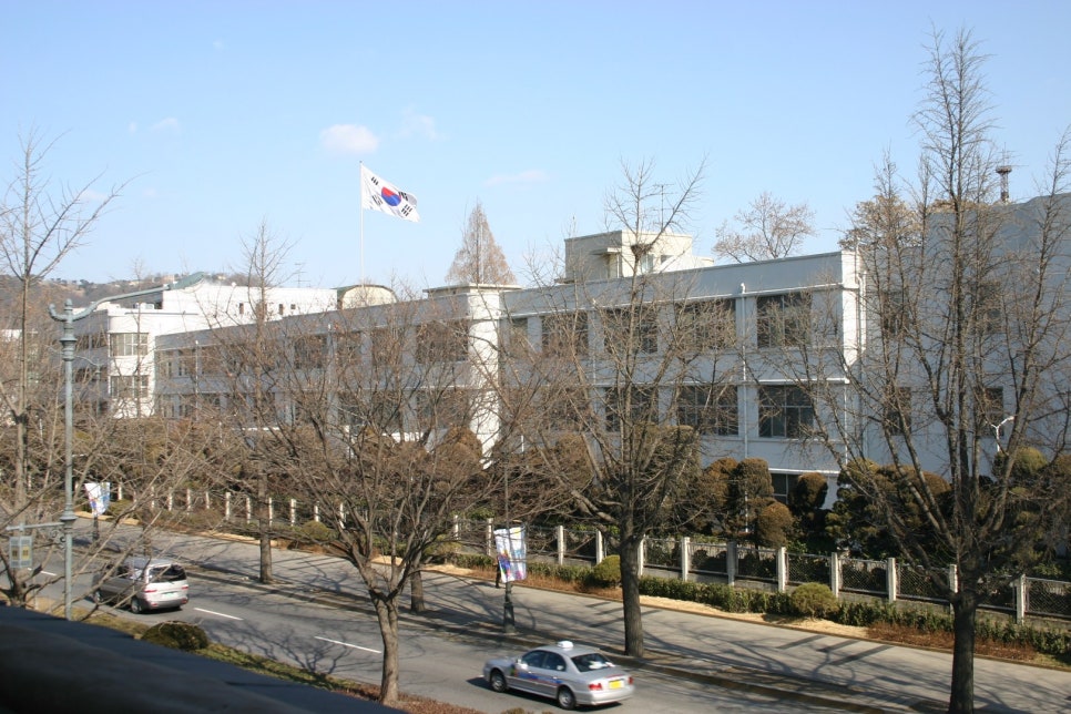 The front of the former Defense Security Command headquarters, a three-storey reinforced-concrete building with large windows set at regular intervals.