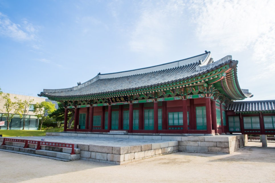The front of Gyeongeundang, a broad stone platform laid before it and painted decoration under the tiled roof.