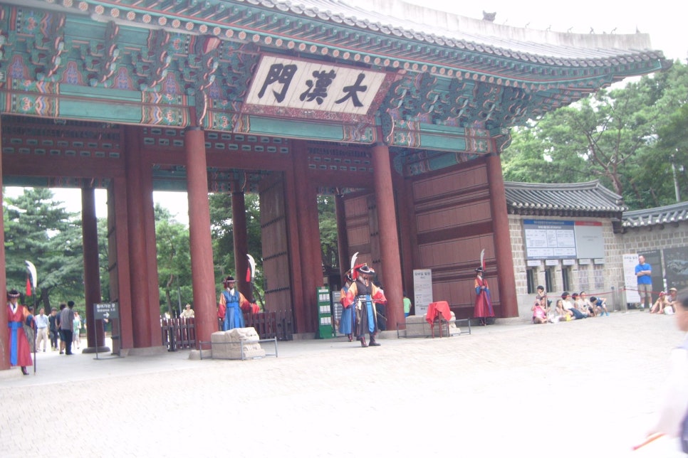 Daehanmun, the main gate of Deoksugung, with its two-storey gatehouse and tiled roof.