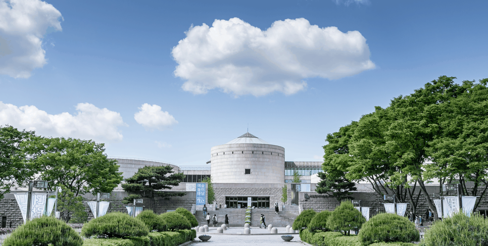 The exterior of the main building at MMCA Gwacheon, with its circular ramp core and the forecourt.