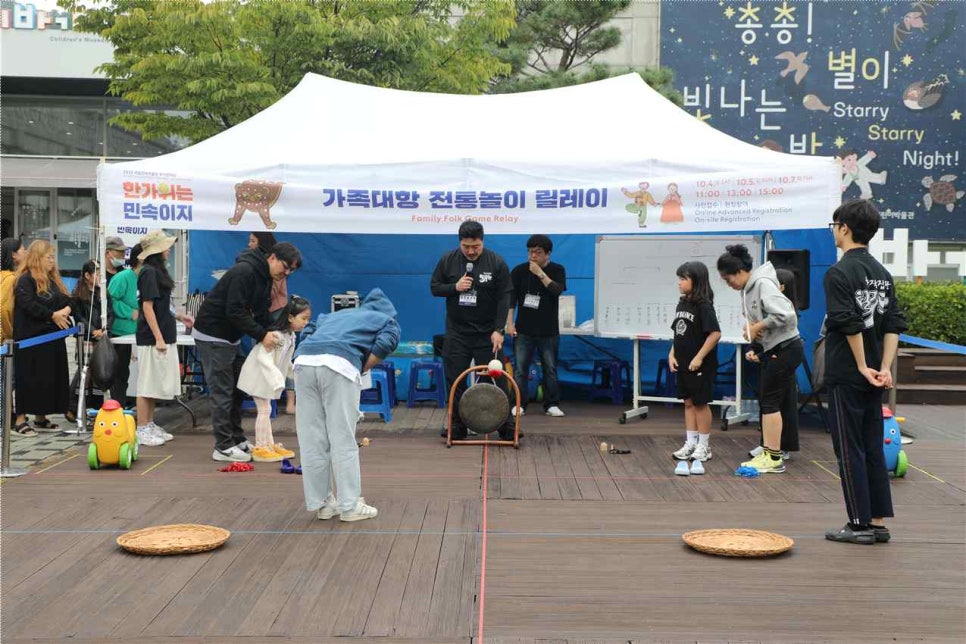 어린이박물관 앞마당에서 가족들이 전래놀이 릴레이를 겨루는 모습