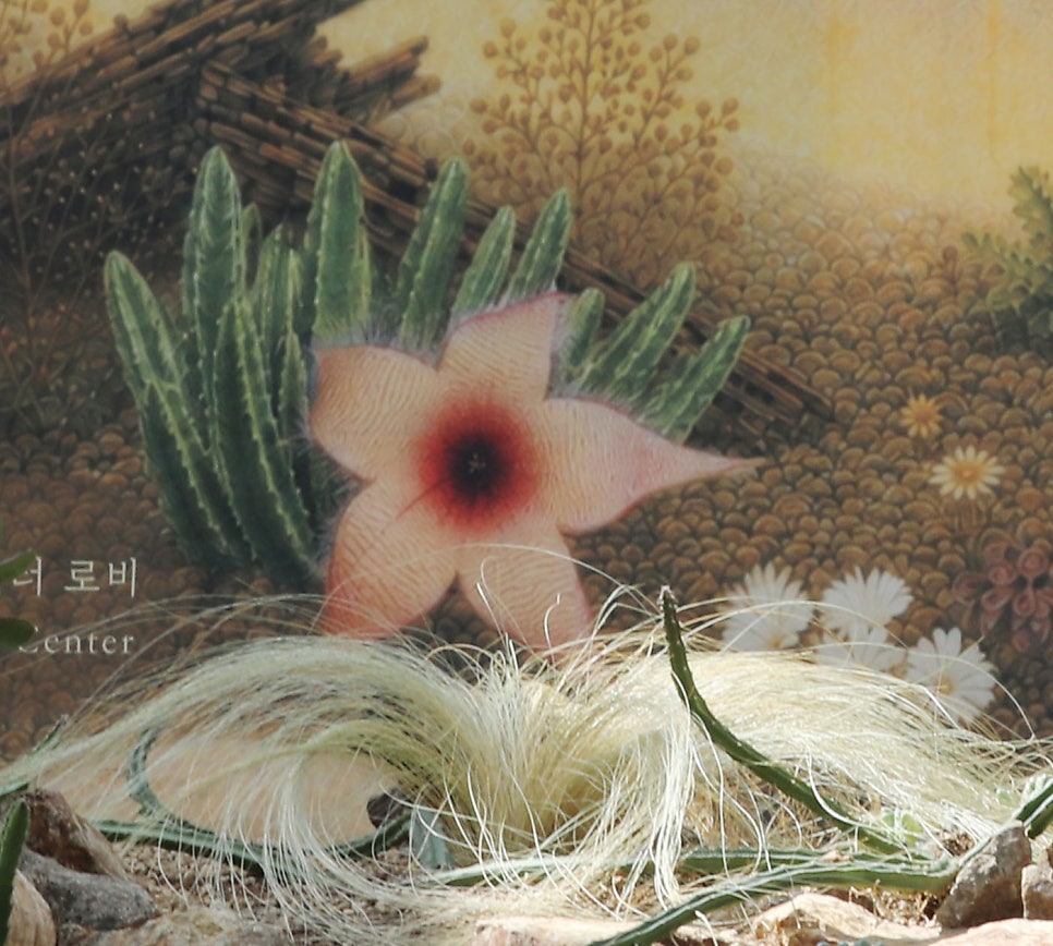 전시 배경 벽에 인쇄된 분홍 별 모양 꽃 일러스트를 가까이 찍은 모습