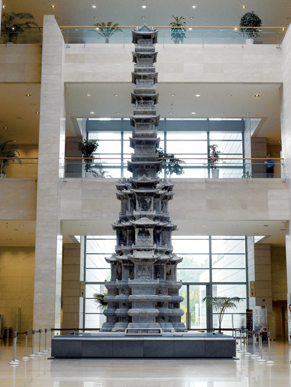 A ten-storey marble pagoda standing in an indoor exhibition space.