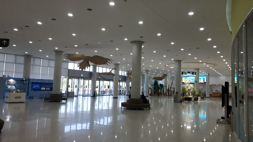 The tall central lobby of the Ecorium, daylight coming through a glazed roof.