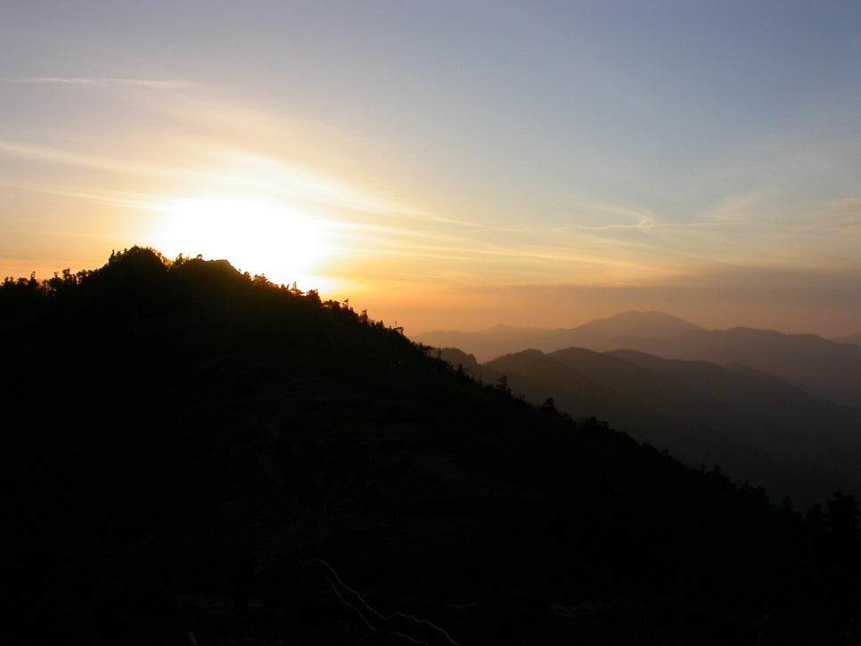 지리산 반야봉 일대에 내리는 저녁 노을. 능선이 겹겹이 이어지고 하늘이 주황빛으로 물들어 있다