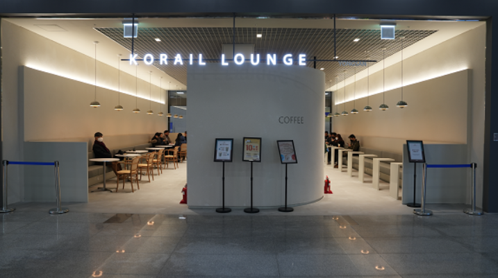 용산역 코레일 라운지 입구. KORAIL LOUNGE 사인과 테이블 좌석이 보여요.