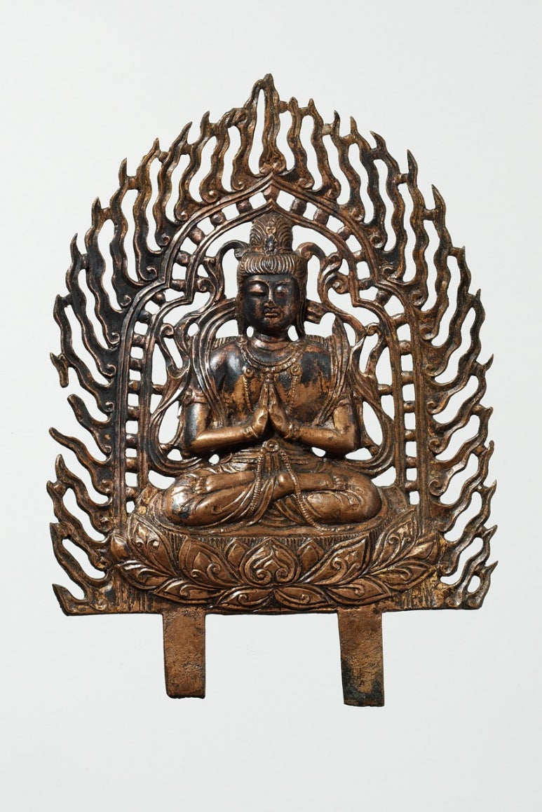 A thin gilt-bronze plaque of a seated bodhisattva on a lotus base, the drapery raised in relief