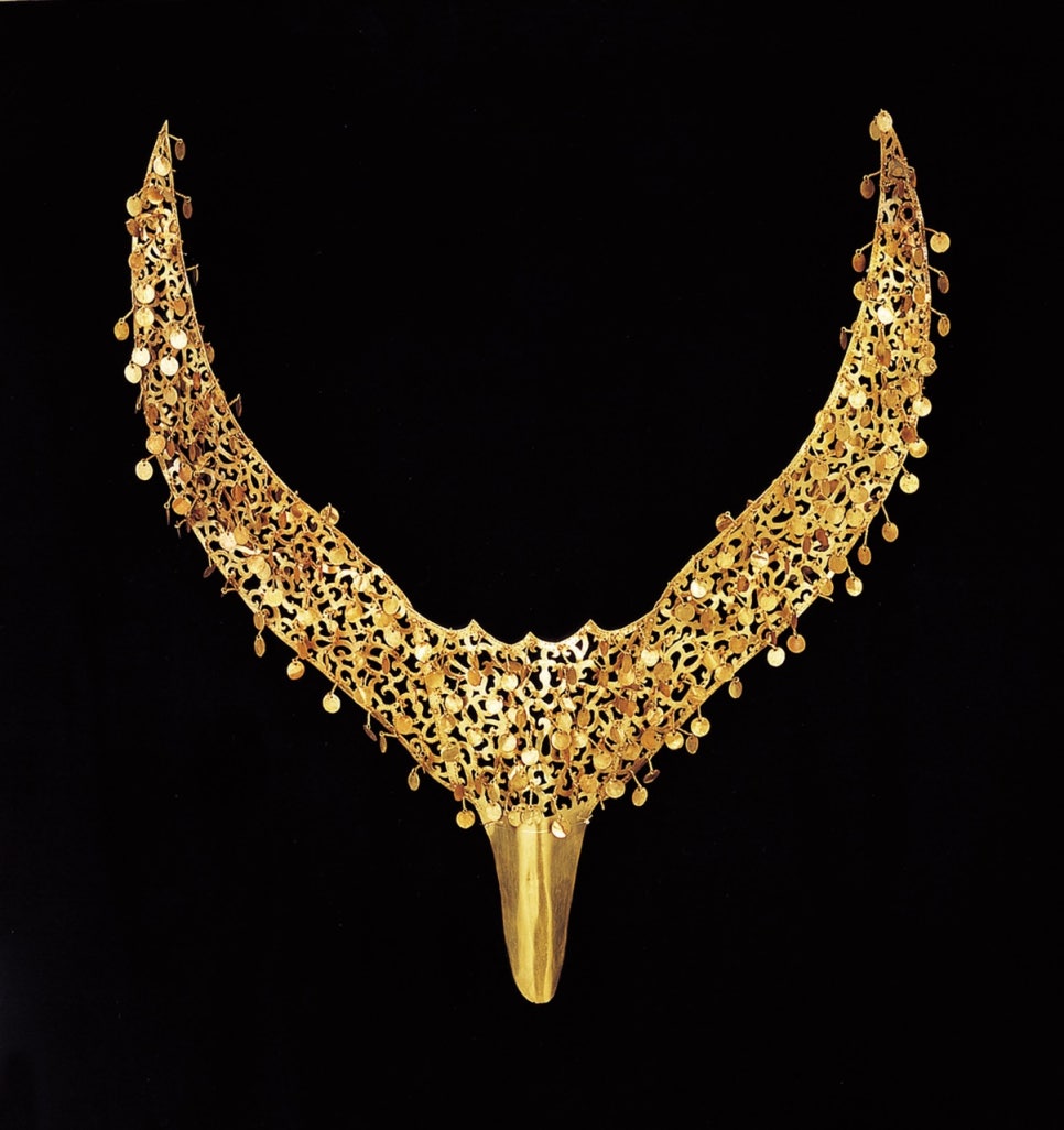 A sheet-gold cap ornament cut into a shape like a bird spreading its wings
