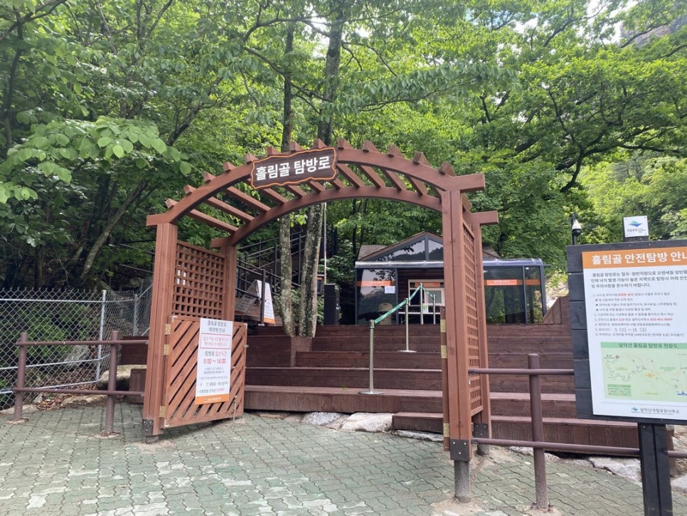 흘림골탐방지원센터 입구의 목재 아치와 '흘림골 안전탐방 안내' 입간판