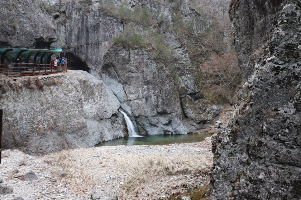 늦가을 용추협곡의 암벽 사이 폭포와 그 옆 탐방로 데크