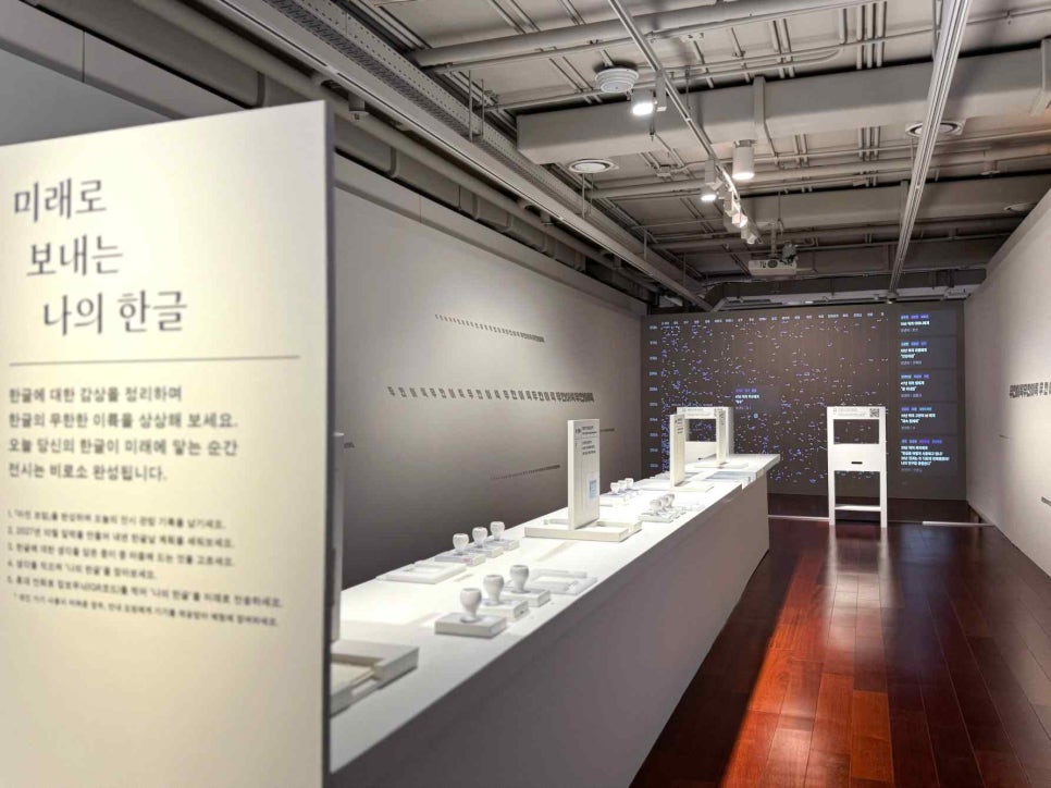 터치스크린 체험대 여러 대가 놓인 3부 체험 공간. 벽면 화면에 한글 단어들이 떠 있다