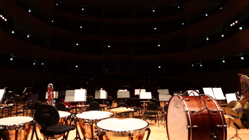 Close view of an empty stage before a concert — timpani, music stands and chairs