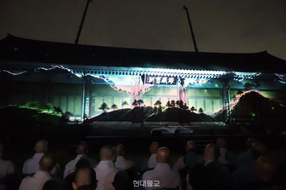 Monks watching a projection of Tongdosa's natural landscape rendered in light