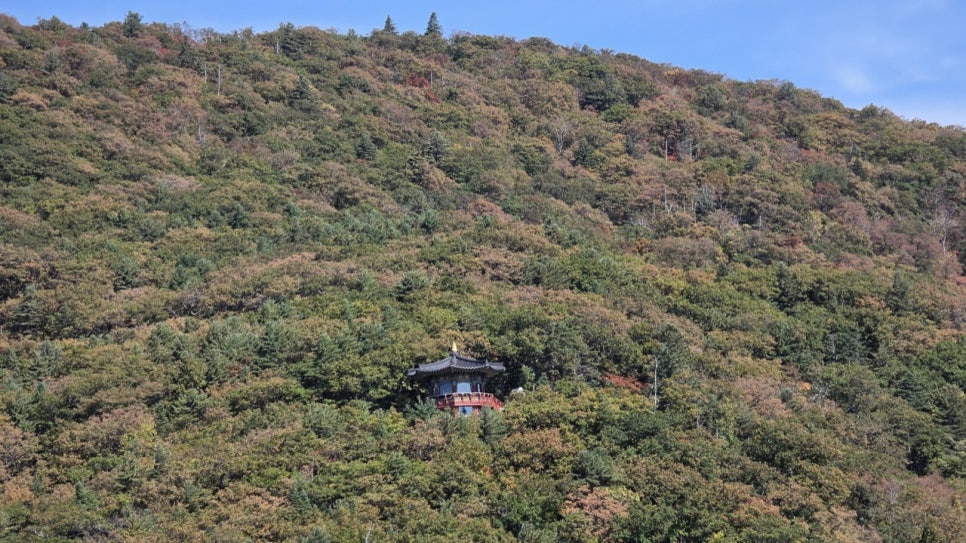 A red autumn slope high on Odaesan with a small hermitage below it