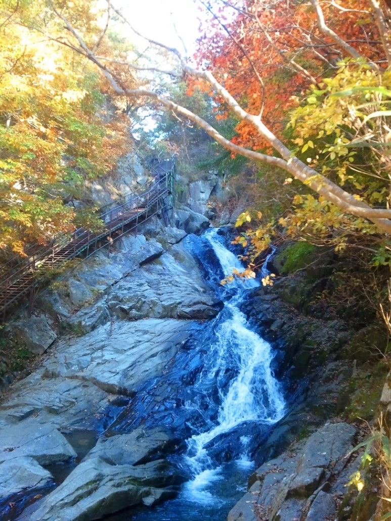 Guryong Falls on Jirisan, water sliding over the rocks between autumn leaves