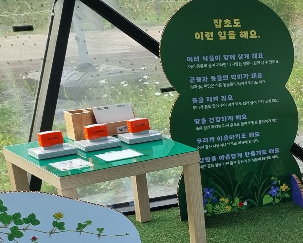 '잡초도 이런 일을 해요'라는 제목의 패널과 앞쪽 스탬프 테이블