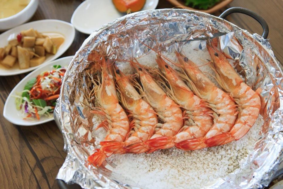굵은 소금을 깐 팬 위에서 붉게 익어 가는 대하구이