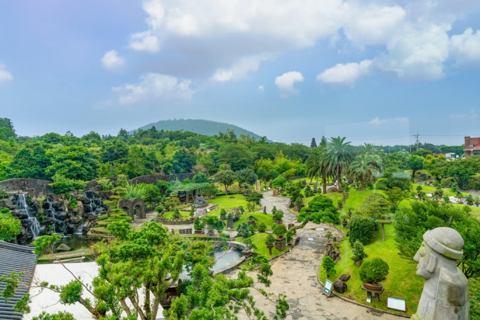 A waterfall and bonsai trees together at Spirited Garden in Jeju