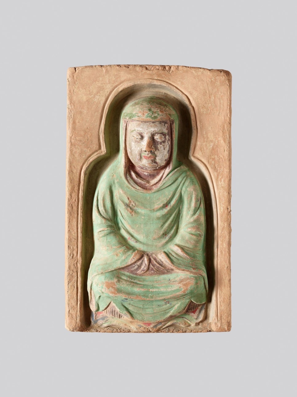 Detail of a seated monk in a red robe, head slightly bowed