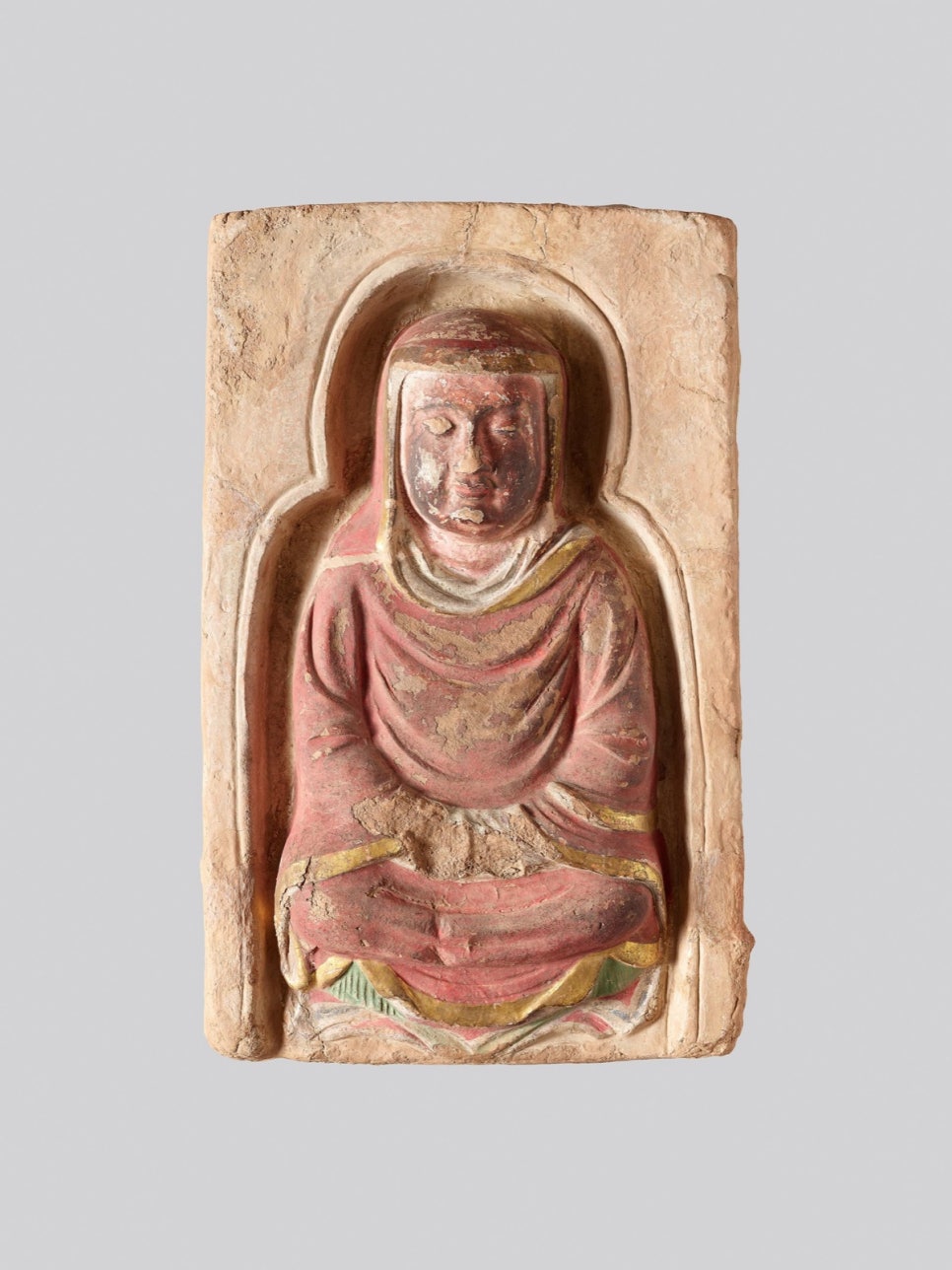Detail of a seated monk in a green robe with hands together