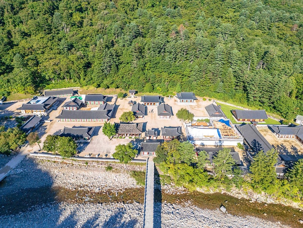 Drone view of Baekdamsa's halls beside the valley, in summer green