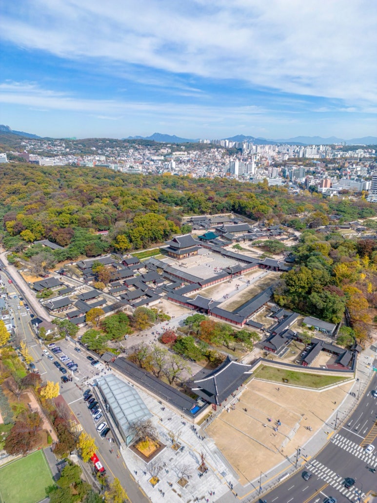 Aerial view of Changdeokgung's halls and woods in autumn