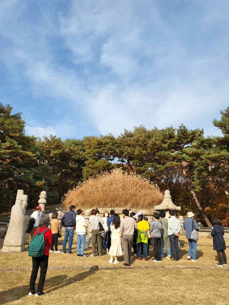 억새 봉분과 석물 앞에 모인 참가자들