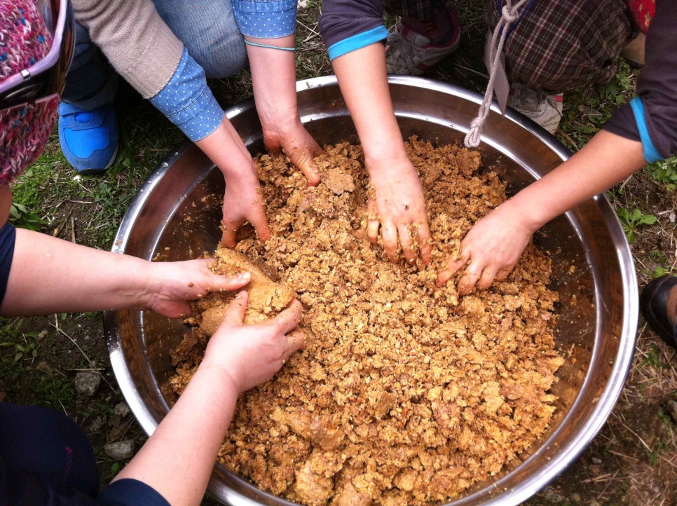 Brine from the jar being poured over the soybean blocks as they are broken up