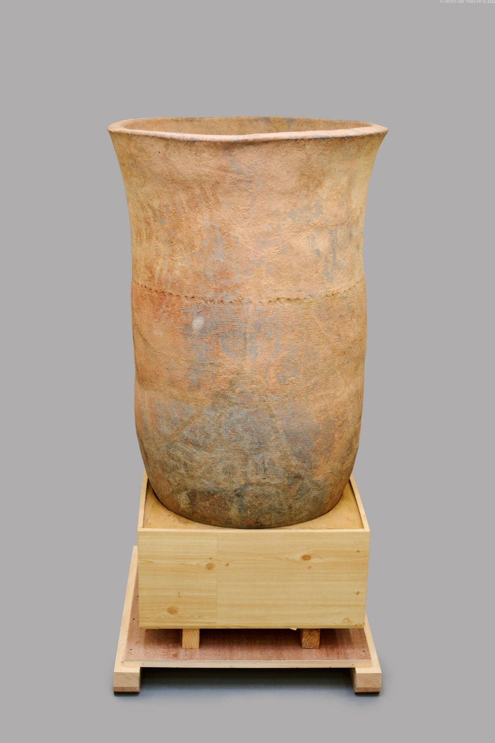Colour photograph of a single large burial jar standing upright, with a wide mouth and long body